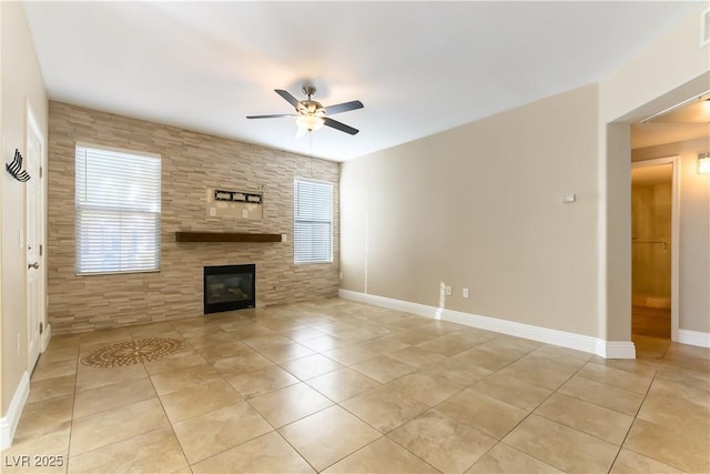 unfurnished living room with ceiling fan, plenty of natural light, a fireplace, and light tile patterned floors