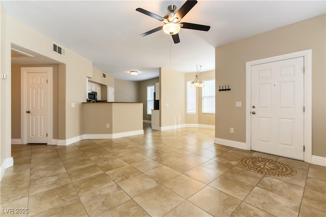 interior space featuring ceiling fan with notable chandelier and light tile patterned floors