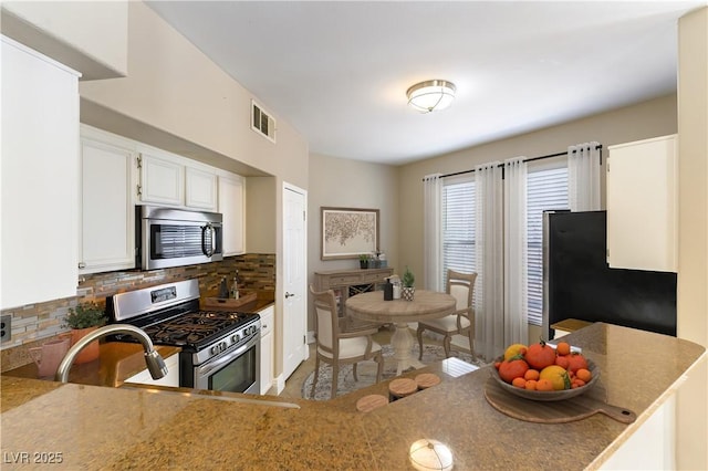 kitchen featuring appliances with stainless steel finishes, sink, white cabinets, and decorative backsplash