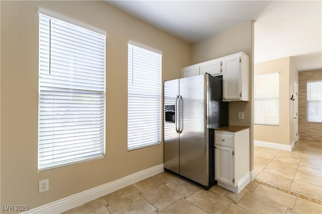 kitchen featuring white cabinetry, stainless steel fridge with ice dispenser, and light tile patterned floors