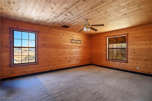 empty room featuring wood ceiling, ceiling fan, wooden walls, and carpet floors