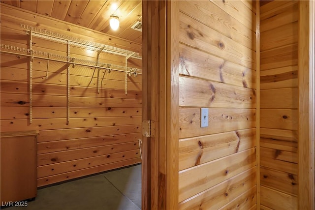 interior space featuring wood ceiling and wooden walls