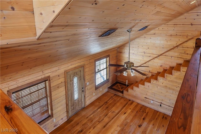 entrance foyer featuring wood-type flooring, lofted ceiling, wooden ceiling, and wooden walls