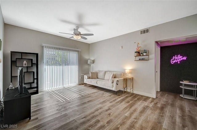 living room featuring wood-type flooring and ceiling fan