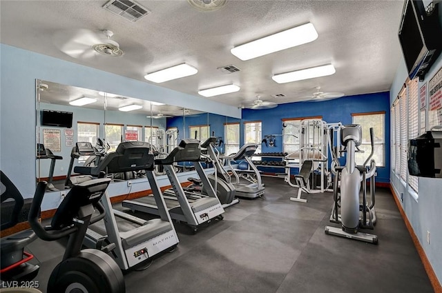 exercise room featuring ceiling fan, a healthy amount of sunlight, and a textured ceiling