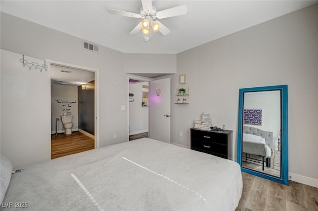 bedroom with ceiling fan, hardwood / wood-style floors, and ensuite bath