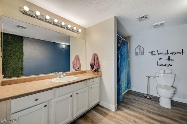 bathroom with toilet, a textured ceiling, vanity, a shower with shower curtain, and hardwood / wood-style flooring