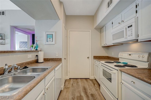 kitchen featuring white appliances, light hardwood / wood-style floors, sink, and white cabinets