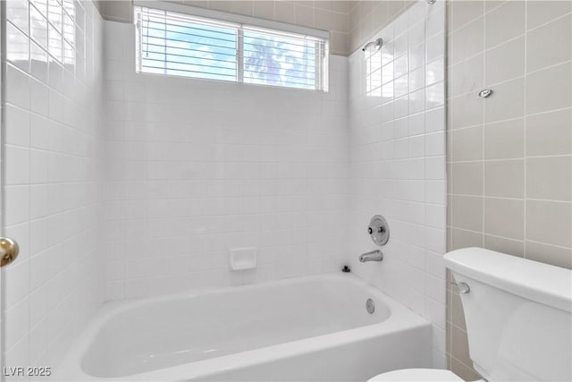 bathroom featuring tiled shower / bath combo and toilet