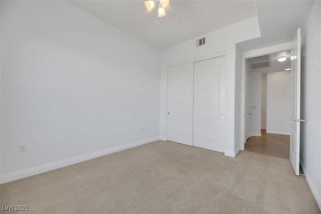 unfurnished bedroom with light carpet, a closet, and ceiling fan