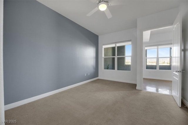 carpeted empty room featuring ceiling fan and vaulted ceiling