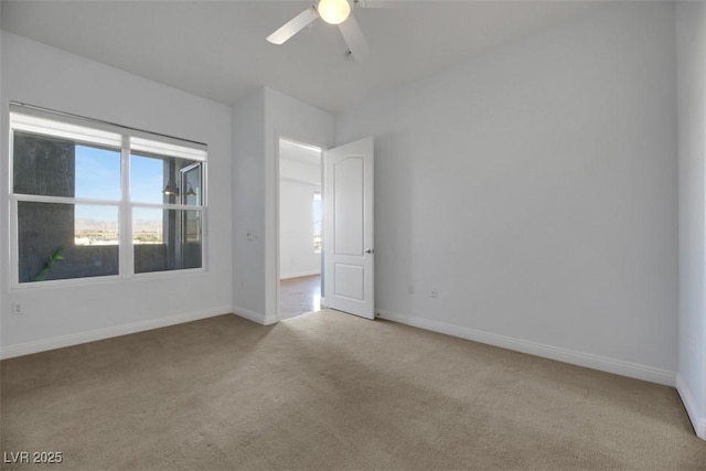 carpeted spare room featuring ceiling fan