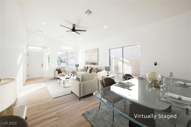 living room featuring ceiling fan, lofted ceiling, and light hardwood / wood-style floors