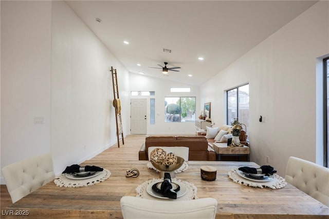 dining space featuring high vaulted ceiling, light hardwood / wood-style floors, and ceiling fan