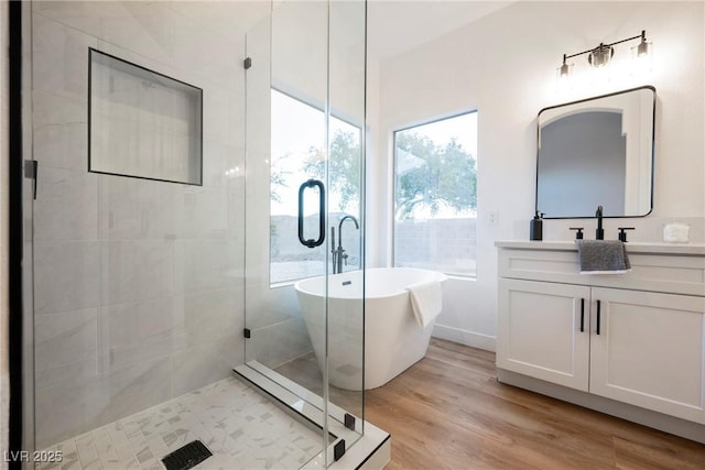 bathroom featuring vanity, separate shower and tub, and hardwood / wood-style floors