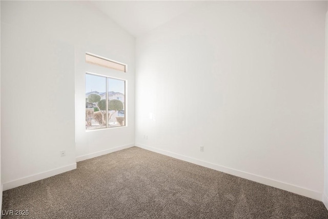 carpeted spare room featuring high vaulted ceiling