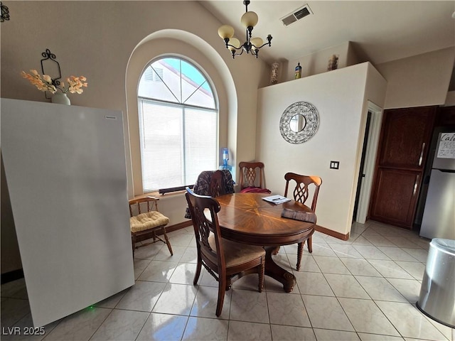 tiled dining space with a wealth of natural light and a chandelier