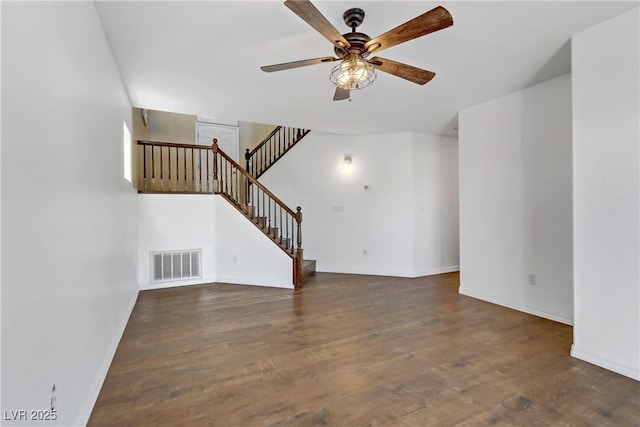 unfurnished living room featuring dark wood-type flooring and ceiling fan