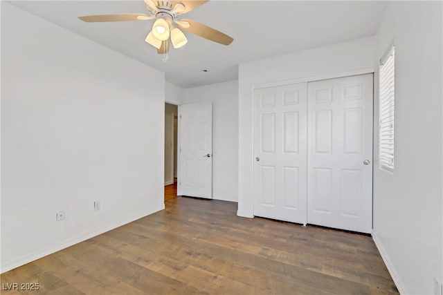 unfurnished bedroom featuring dark hardwood / wood-style floors, ceiling fan, and a closet