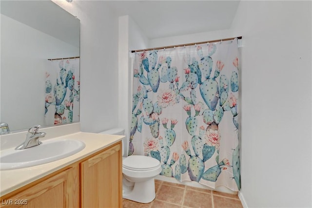 bathroom featuring tile patterned flooring, vanity, toilet, and walk in shower