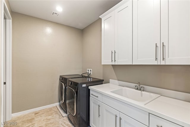 washroom with separate washer and dryer, sink, and cabinets