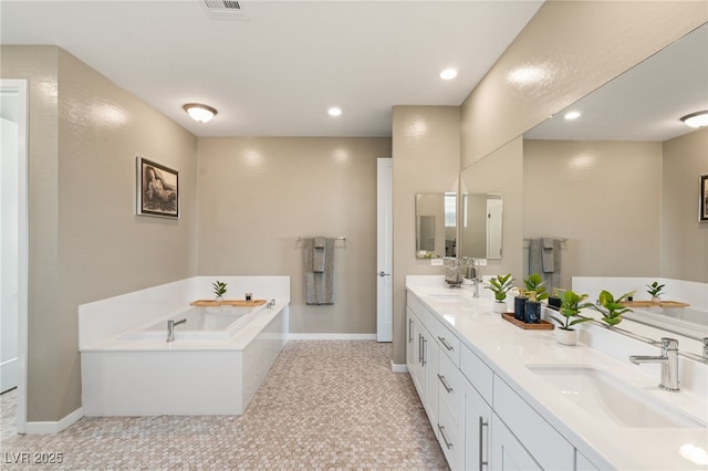 bathroom with tile patterned flooring, vanity, and a bath