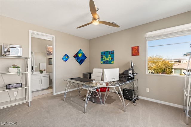 carpeted office featuring ceiling fan