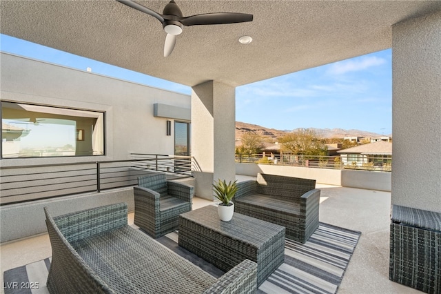 view of patio with ceiling fan, outdoor lounge area, a mountain view, and a balcony