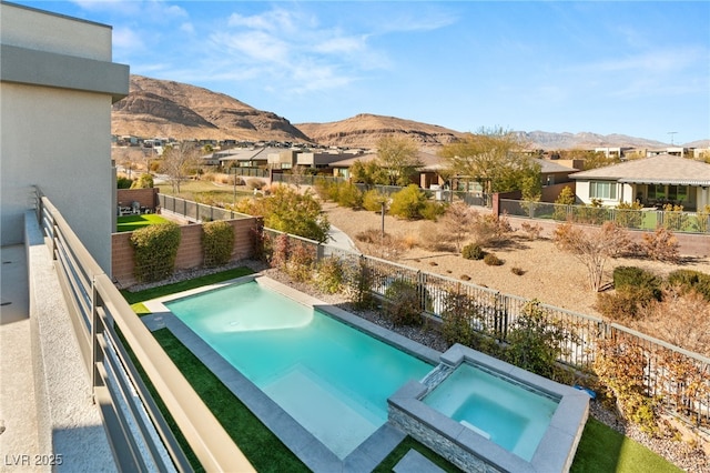 view of swimming pool with an in ground hot tub and a mountain view