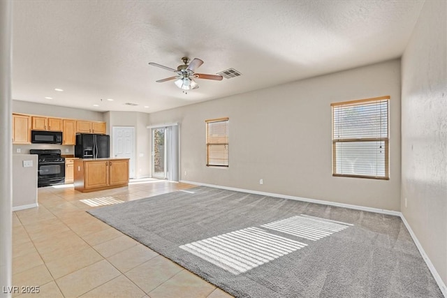 unfurnished living room featuring a wealth of natural light, a textured ceiling, ceiling fan, and light tile patterned floors