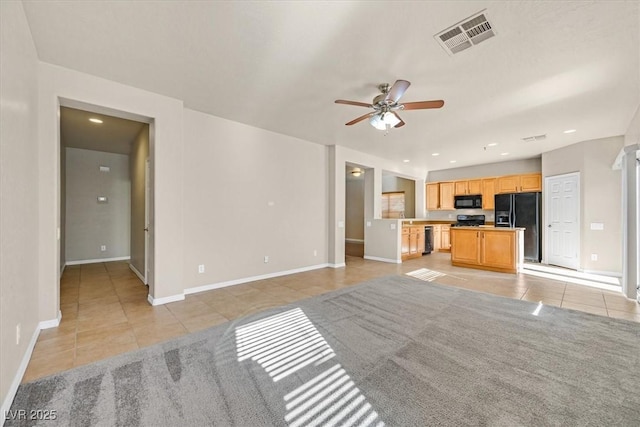 unfurnished living room featuring ceiling fan and light tile patterned floors