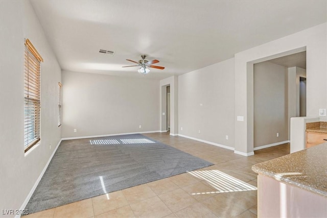 empty room featuring light tile patterned floors and ceiling fan