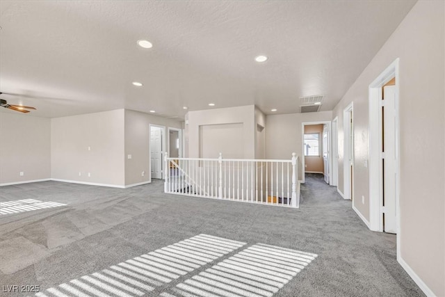 carpeted spare room with ceiling fan