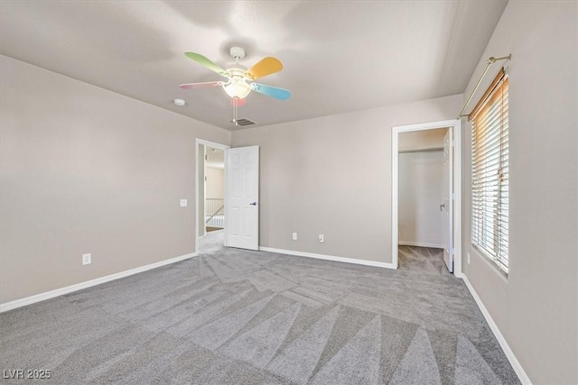 unfurnished bedroom featuring a spacious closet, carpet floors, and ceiling fan