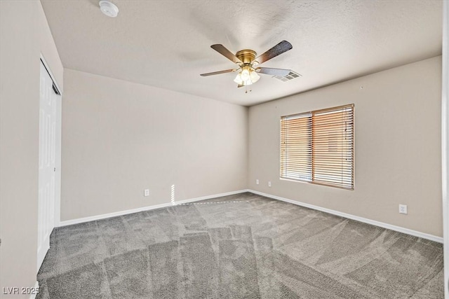 spare room featuring ceiling fan, carpet floors, and a textured ceiling