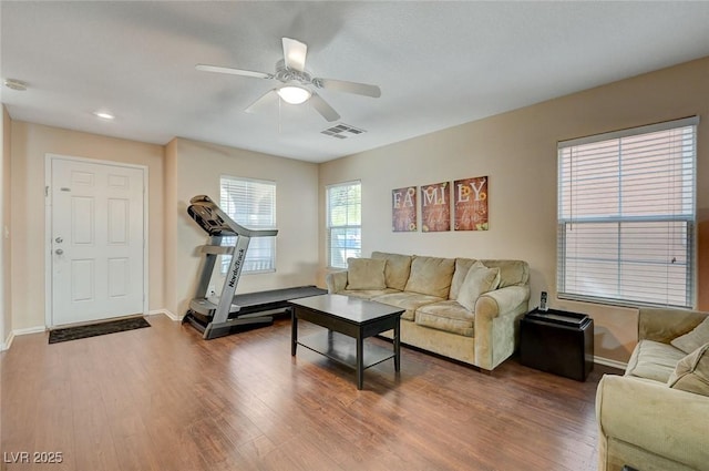 living room with wood-type flooring and ceiling fan