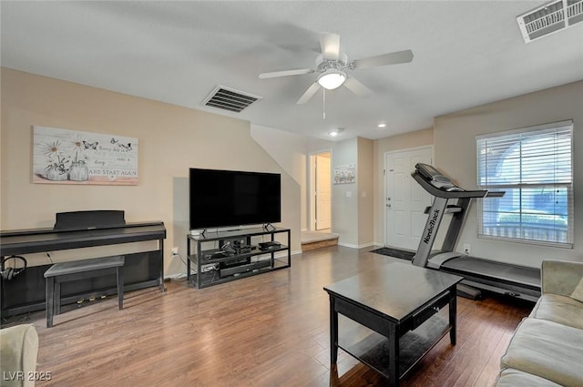 living room with ceiling fan and dark hardwood / wood-style flooring