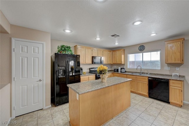 kitchen featuring light brown cabinetry, sink, black appliances, and a center island