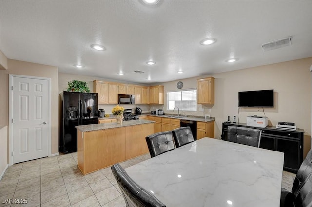 kitchen with sink, black appliances, light stone countertops, and a kitchen island