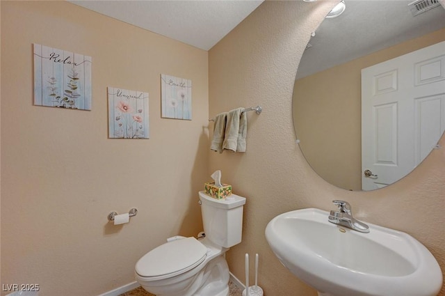 bathroom featuring sink, a textured ceiling, and toilet