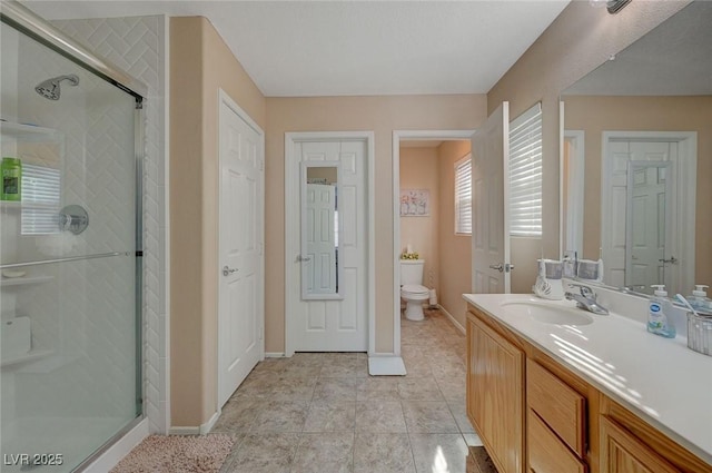 bathroom with tile patterned floors, vanity, toilet, and an enclosed shower