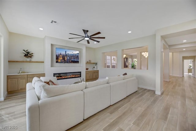 living room featuring ceiling fan and light hardwood / wood-style flooring