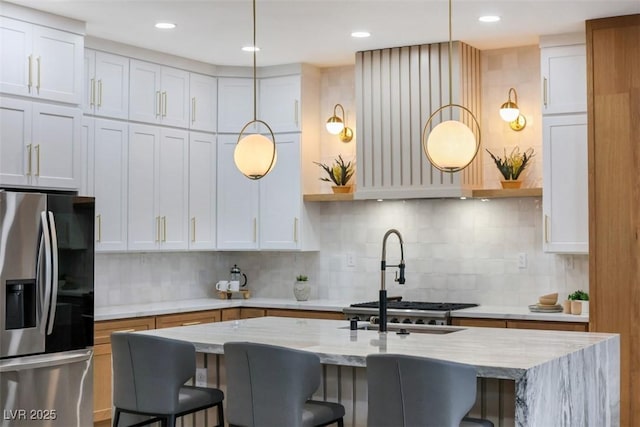 kitchen featuring white cabinetry and stainless steel refrigerator with ice dispenser