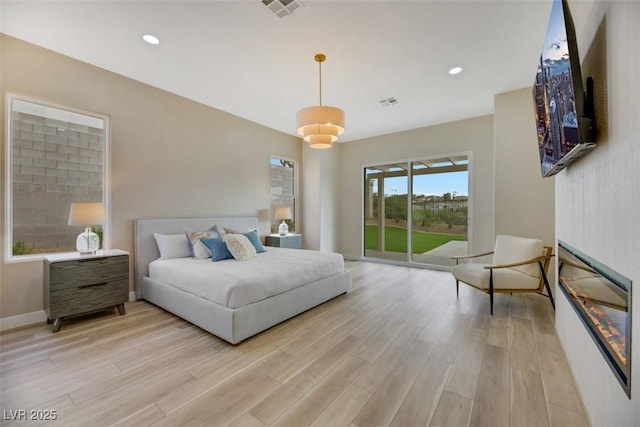 bedroom featuring light wood-type flooring and access to outside