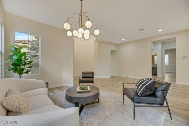 living room with a notable chandelier and light wood-type flooring