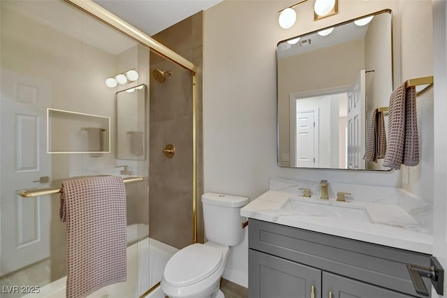 bathroom with an enclosed shower, vanity, and toilet