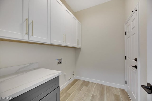 laundry area featuring cabinets, gas dryer hookup, hookup for a washing machine, and light hardwood / wood-style flooring