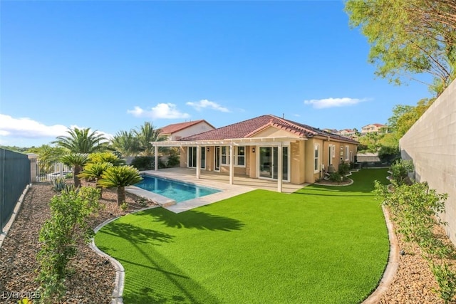 back of property featuring a fenced in pool, a yard, and a patio