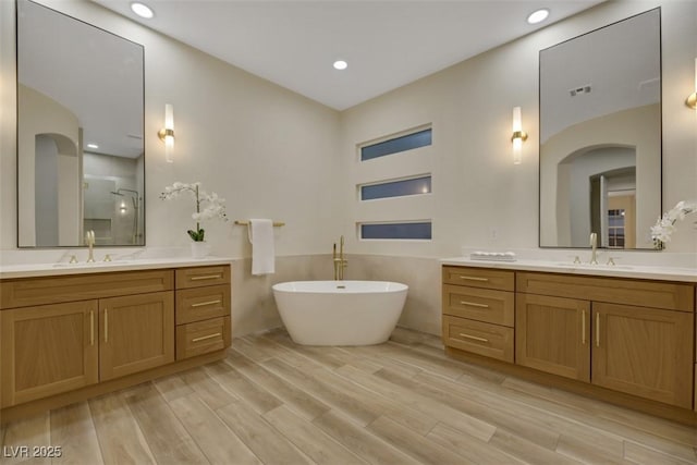 bathroom with vanity and shower with separate bathtub