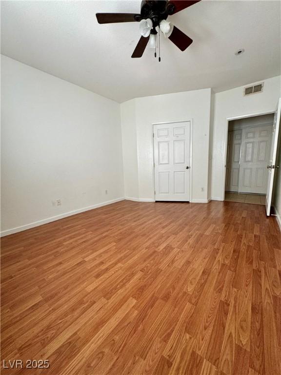 unfurnished bedroom featuring ceiling fan, a closet, and light wood-type flooring